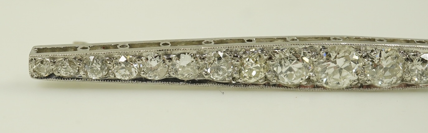 A 1920's platinum? and nineteen millegrain set graduated diamond bar brooch, 59mm, gross weight 4.6 grams. Condition - fair to good